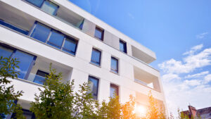 Home - building with blue sky trees background scaled