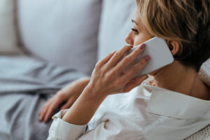 Home - distraught woman resting sofa communicating mobile phone scaled