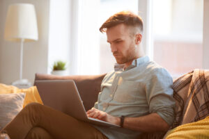 Home - handsome man using laptop home scaled