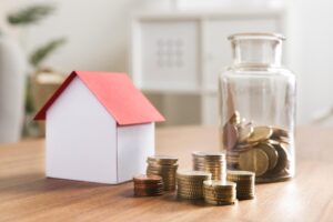 Home - miniaturbank mit munzstapeln und glas daneben scaled