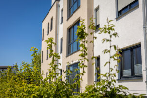 Home - modern residential building exterior with green foliage clear blue sky scaled