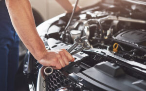 Home - muskuloser autoservice arbeiter der fahrzeug repariert scaled