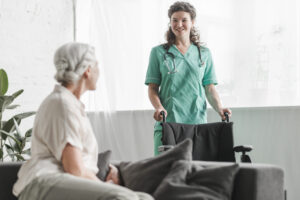 Home - senior woman looking smiling female nurse with wheelchair scaled